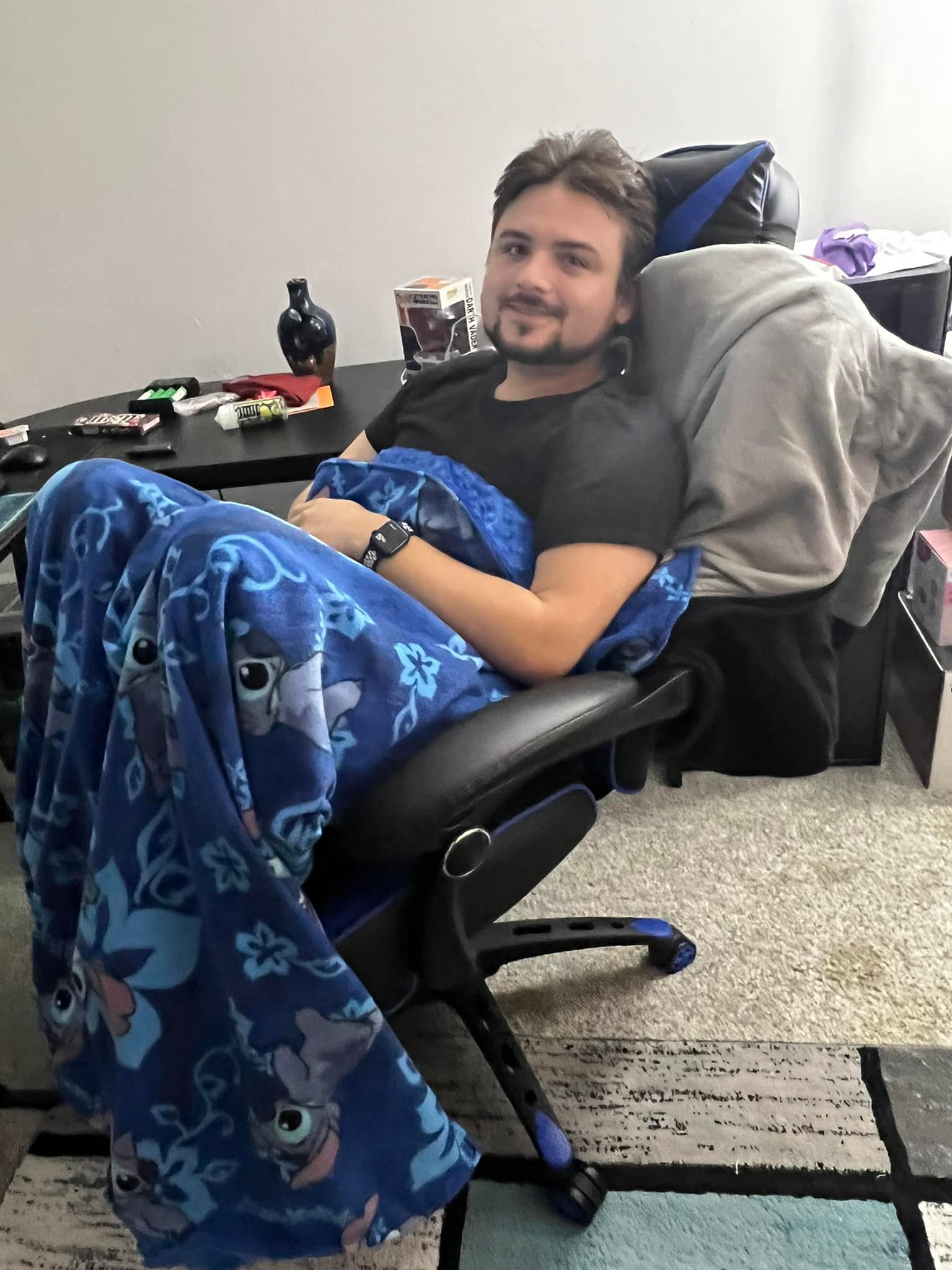 A happy customer using a handmade stitch blanket.